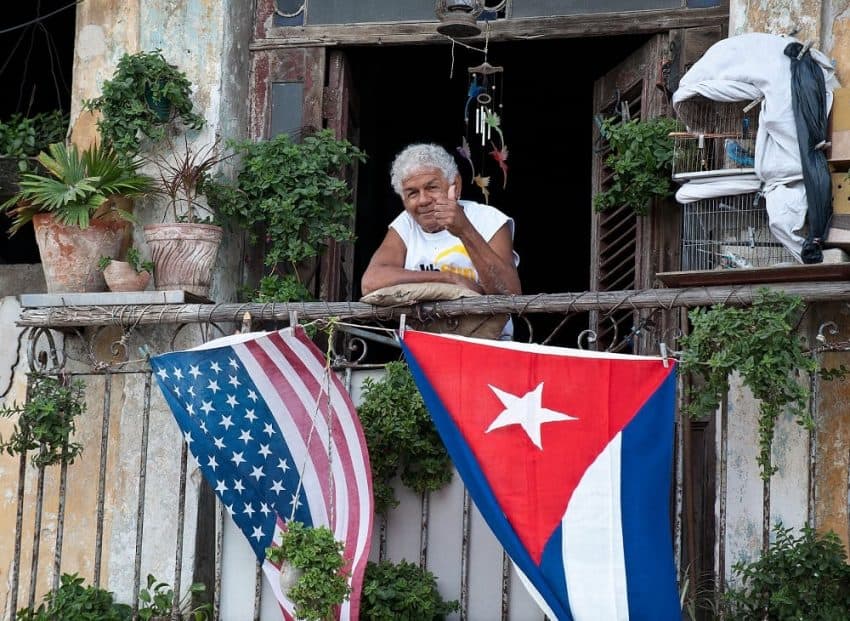 How to travel to Cuba - Cuban giving thumbs up from balcony (1)